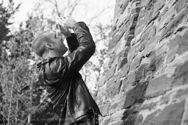 Person taking an iphone photo next to a stone wall