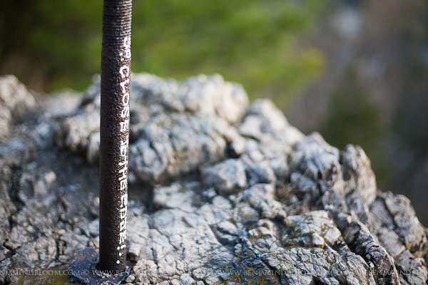 Metal rebar stuck in stone with the words "So Close to the Edge"